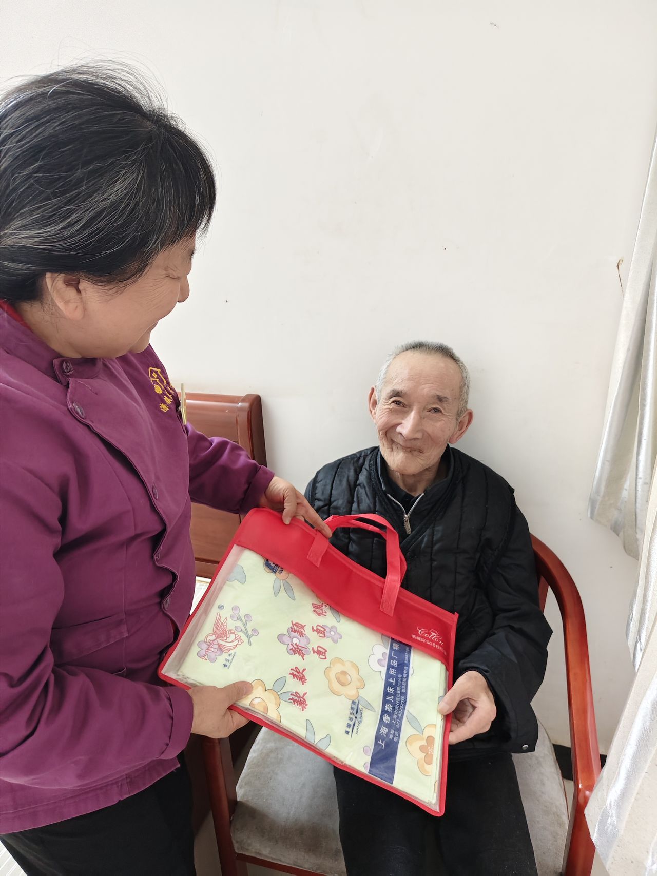 工作人员为行动不便的长辈送礼品上门